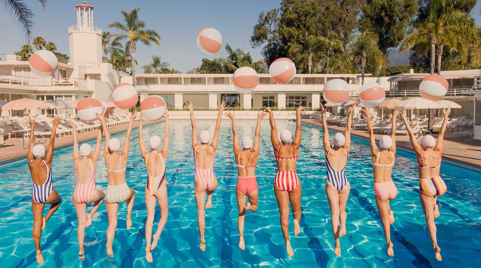 Women jumping into a pool