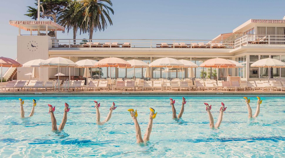 Women in a pool with feet in the air