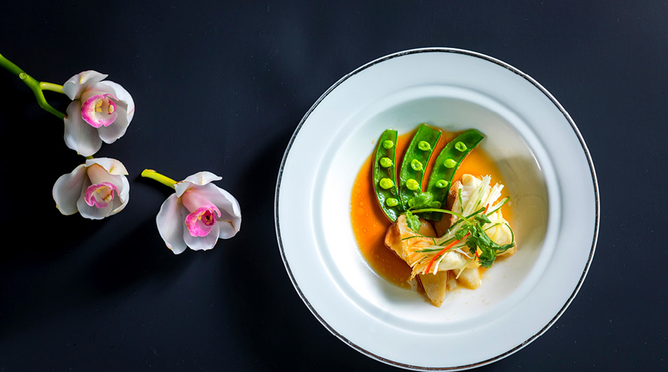 Grouper on a white plate with yams and spring onion