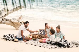 Sdi 377 970x646A man, woman and two children picnic on the beach just a couple feet away from the ocean