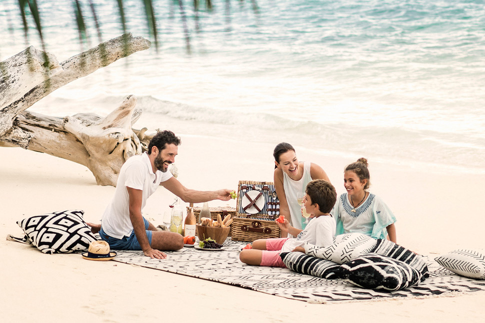 Sdi 377 970x646A man, woman and two children picnic on the beach just a couple feet away from the ocean