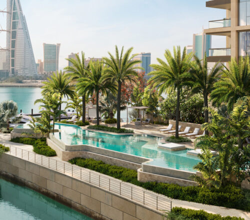 Palm-fringed outdoor pool set on a terrace next to the river