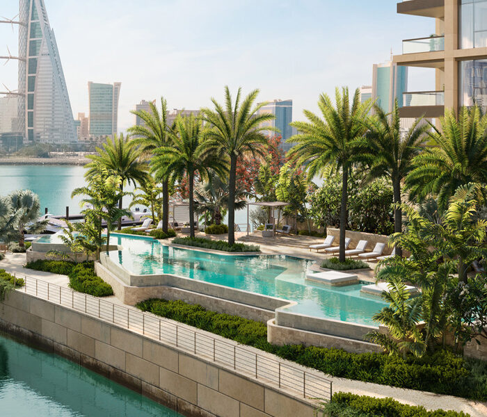 Palm-fringed outdoor pool set on a terrace next to the river