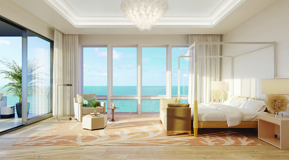Bedroom with white walls, light-wood floors, a four-post canopy bed with white linens and two walls of windows overlooking the ocean