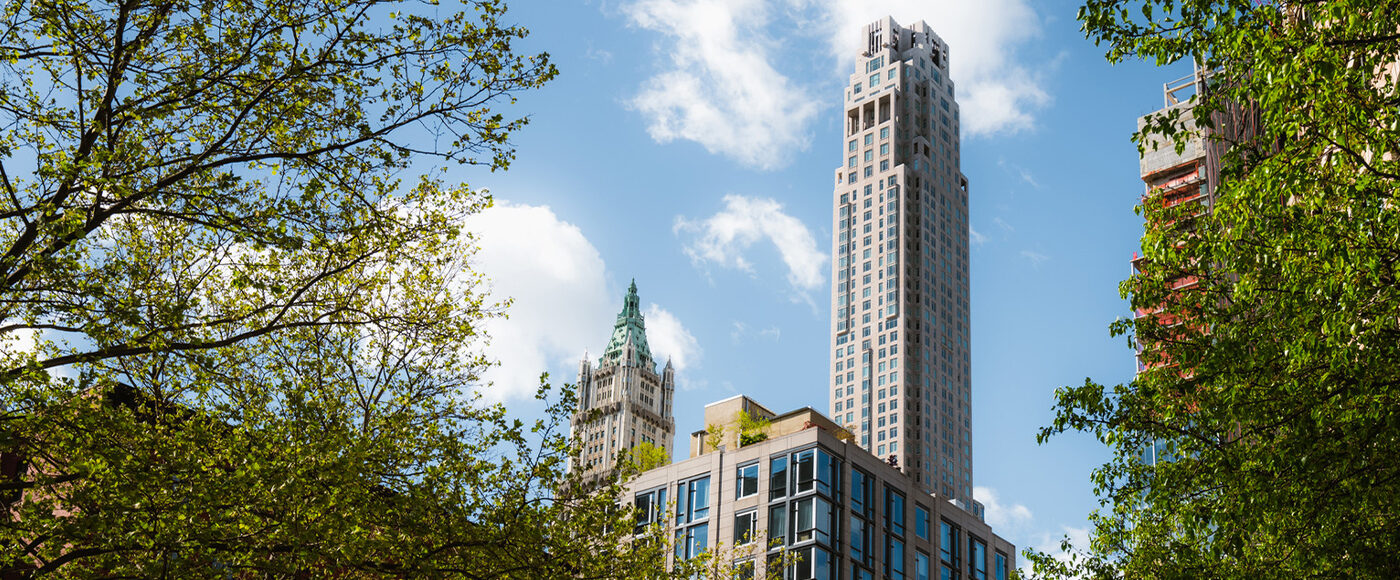 View of downtown New York skyscraper and buildings framed by trees in the summer