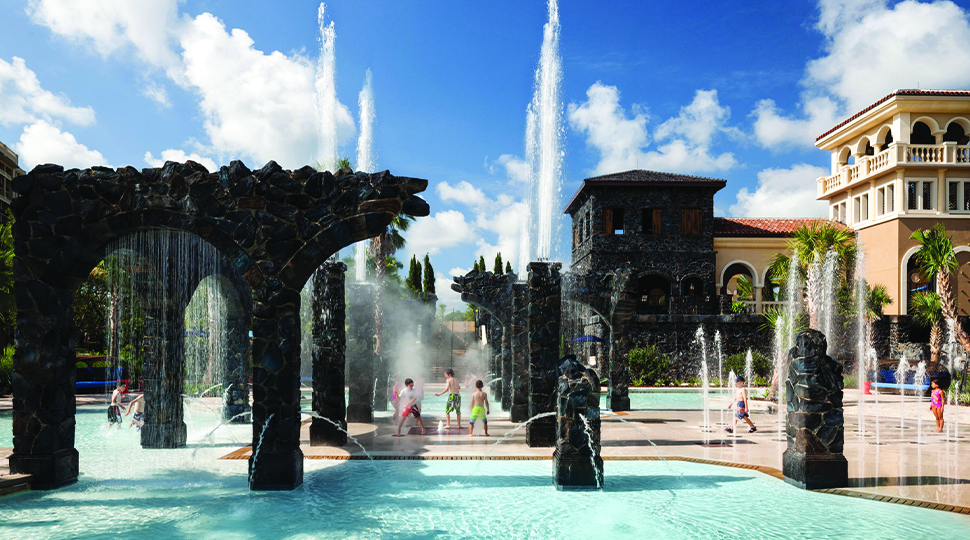 Splash pad and water fountains next to a pool