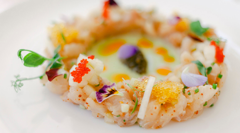 Seafood dish with delicate and colourful garnishes on a white plate