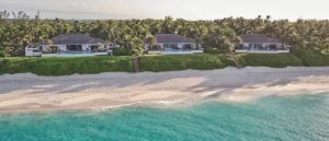 Three beachfront villas line the shore