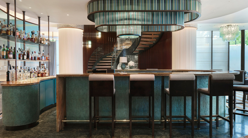 Bar counter of restaurant with five stools and a teal and white colour palette