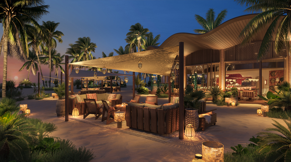 Covered dining patio surrounded by palm trees at night