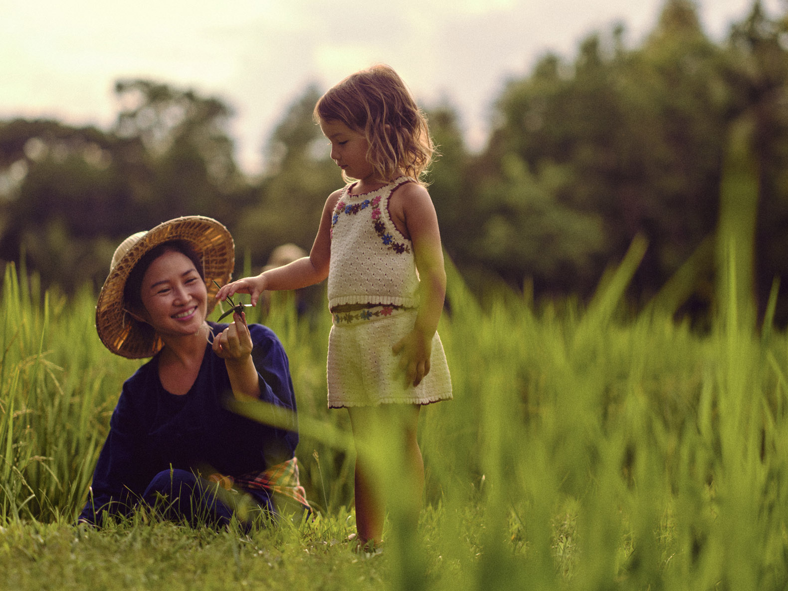 Four Seasons Chiang Mai rice farmer sharing leaf figurine with girl