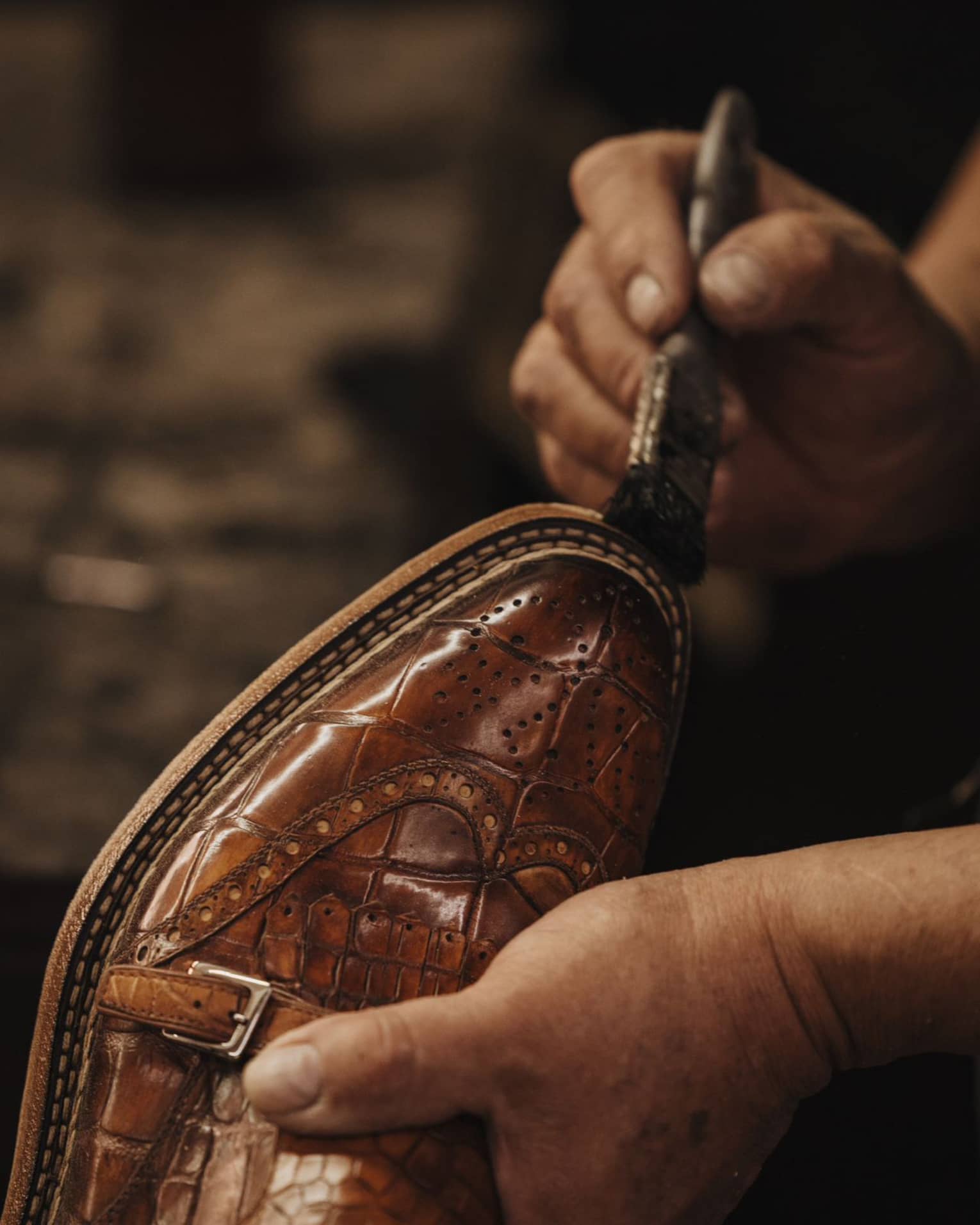 Paintbrush on brown leather shoe.