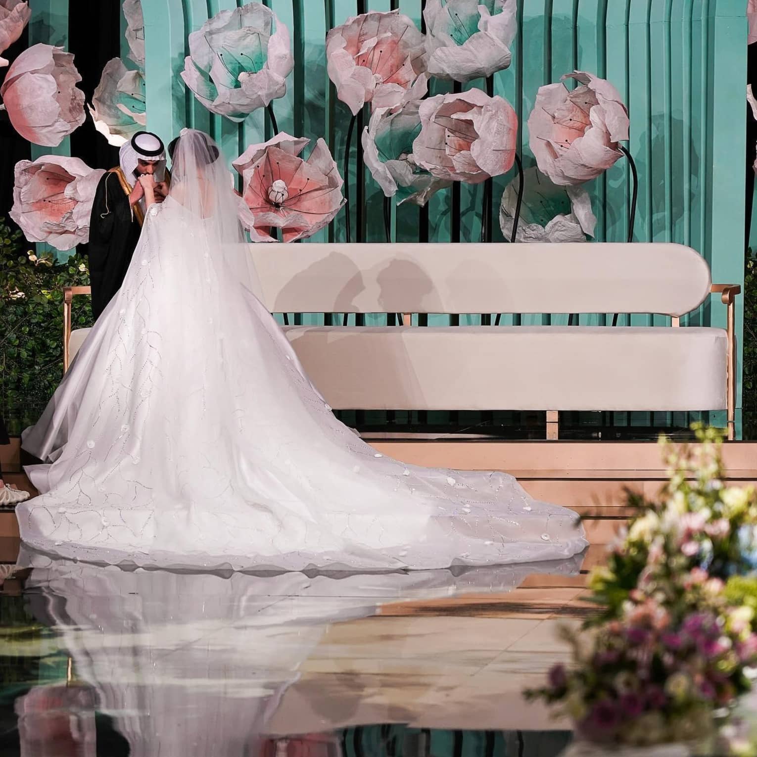 A bride and groom stand in an ornately decorated venue