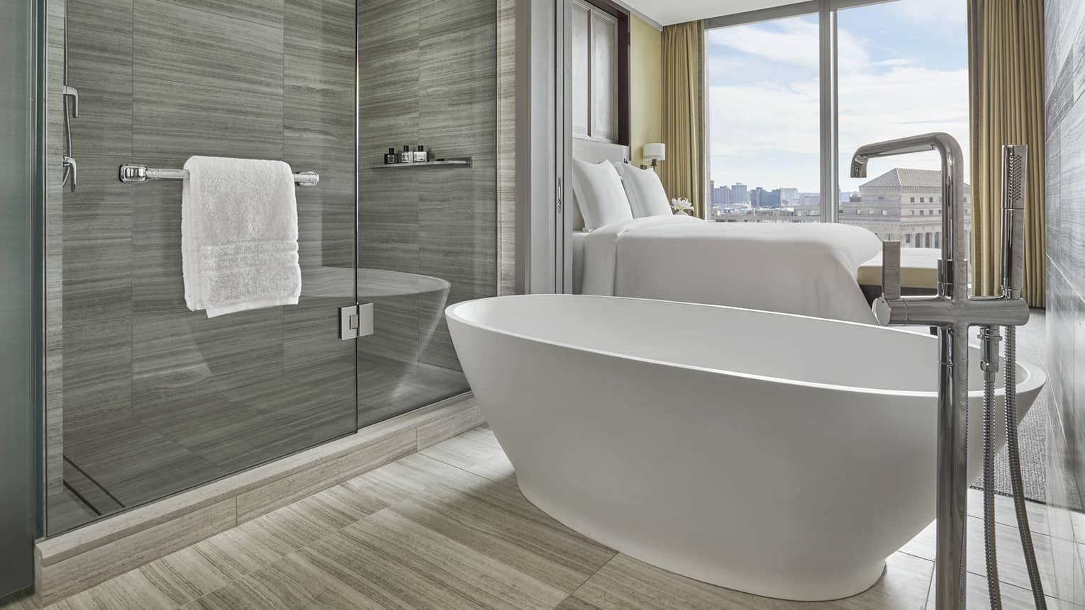 free standing tub and glass paneled walk in shower in a hotel bathroom