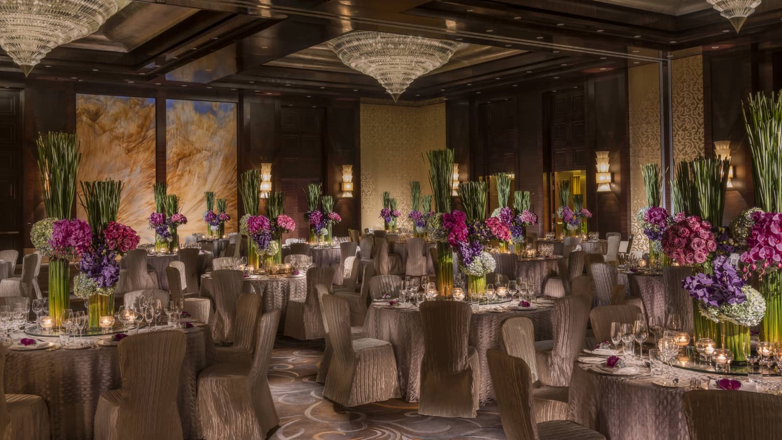 Imperial Ballroom wedding reception with fabric-covered chairs, floral centrepieces, crystal chandeliers