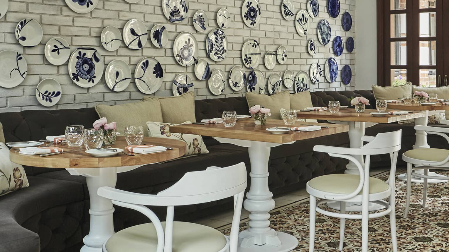 A small cafe area with a wall displaying blue and white china. 
