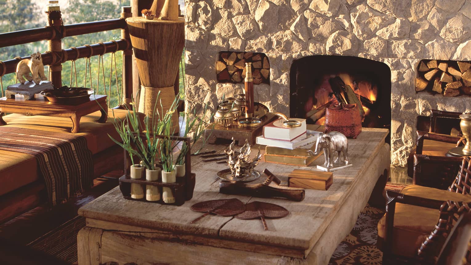 Nong Yao Restaurant wood table with art, statues in front of stone fireplace 