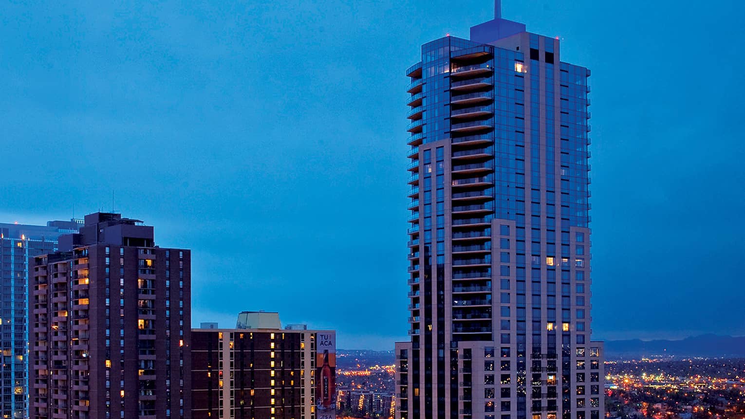 Aerial view of Four Seasons Hotel Denver high rise against skyline at night