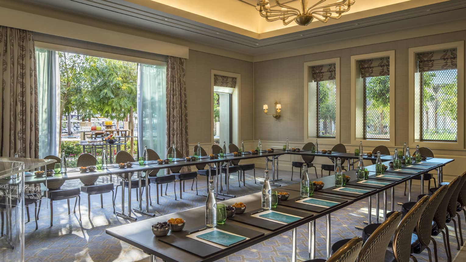 Modular tables and executive chairs arranged in sunny beachfront meeting space 