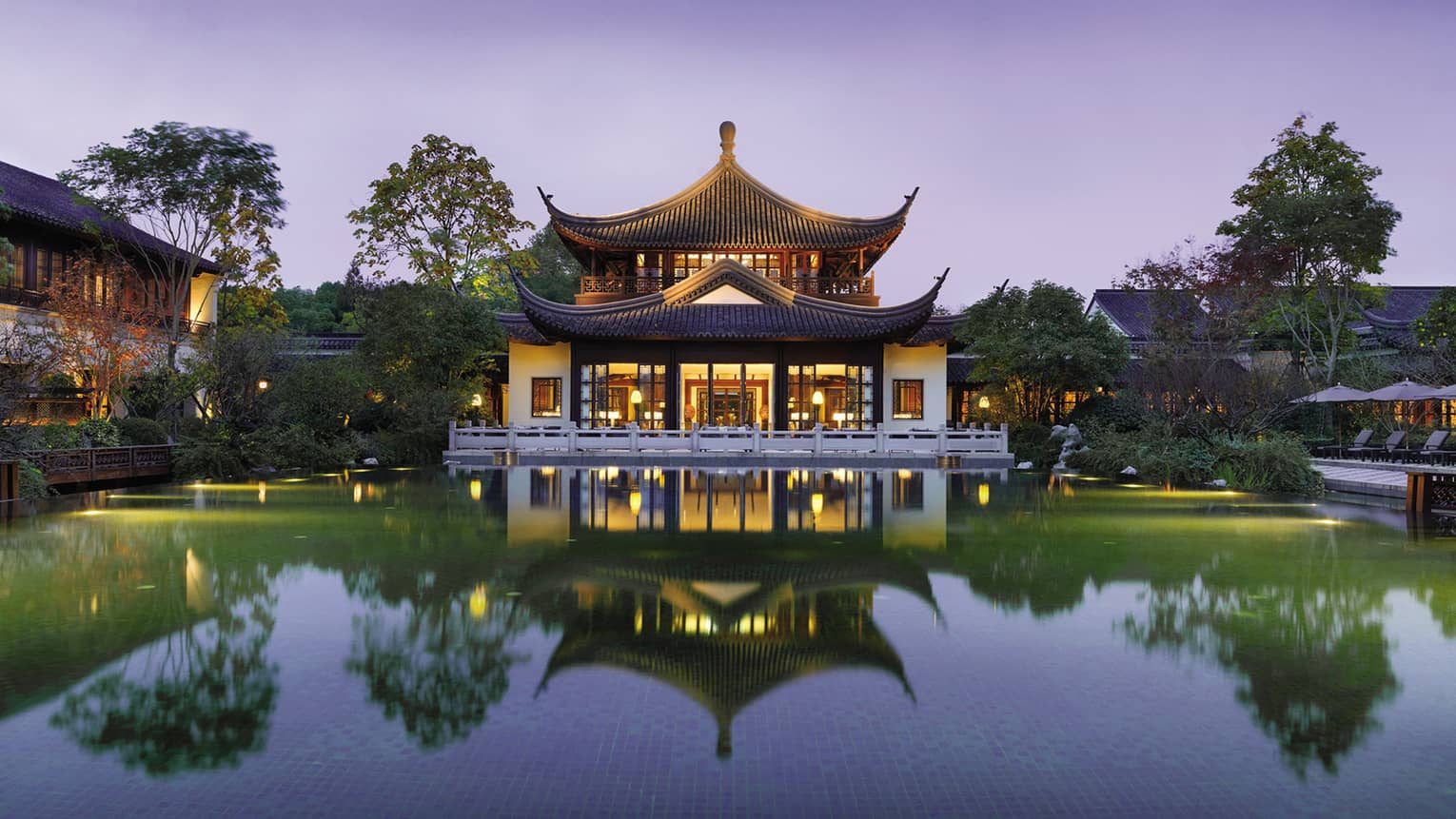 Four Seasons Hotel Hangzhou exterior, reflection in large pool at dusk
