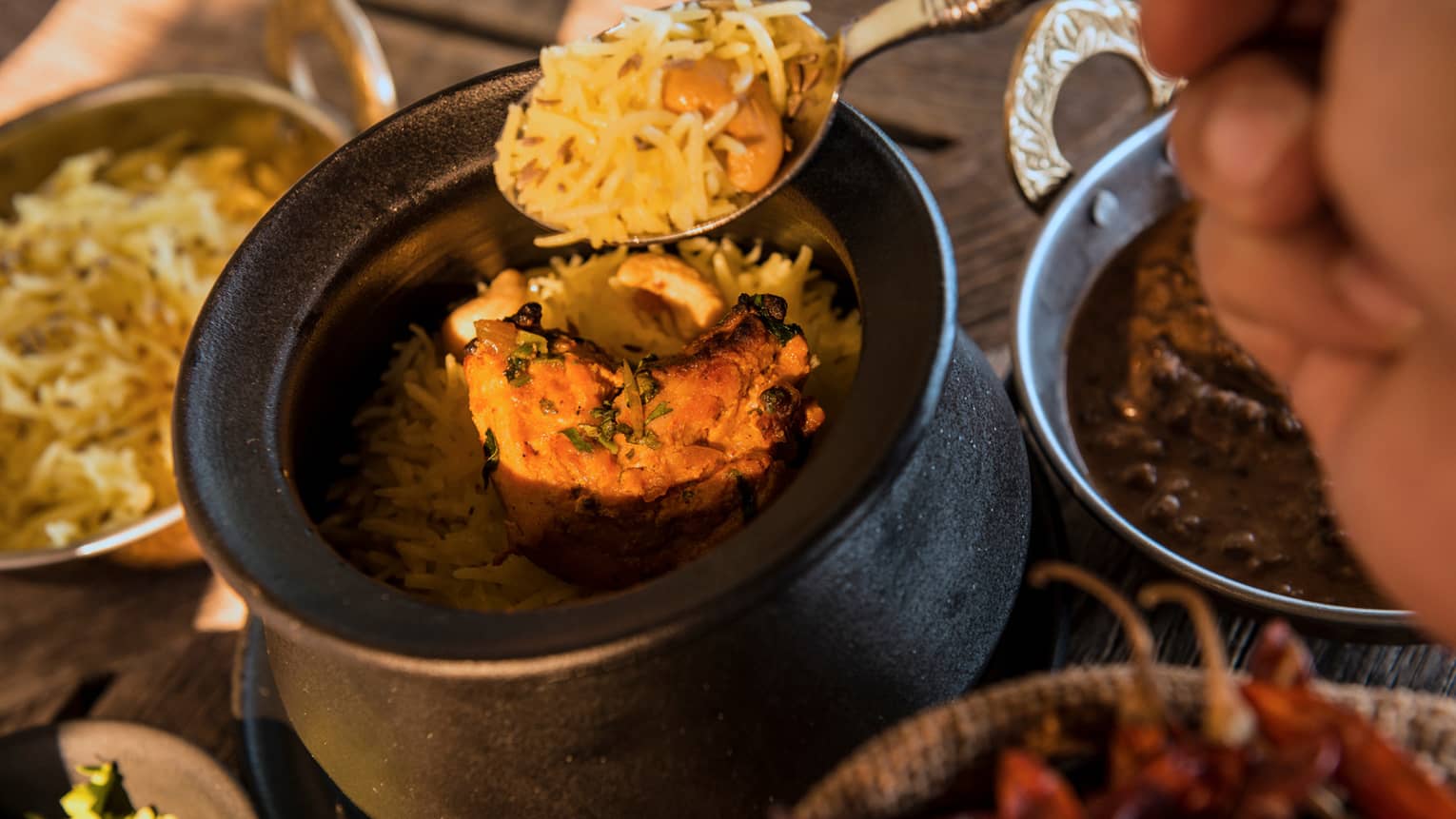 Spoon digging into Tandoori Murgh dish with rice, marinated spring chicken, chillies, cumin and yoghurt
