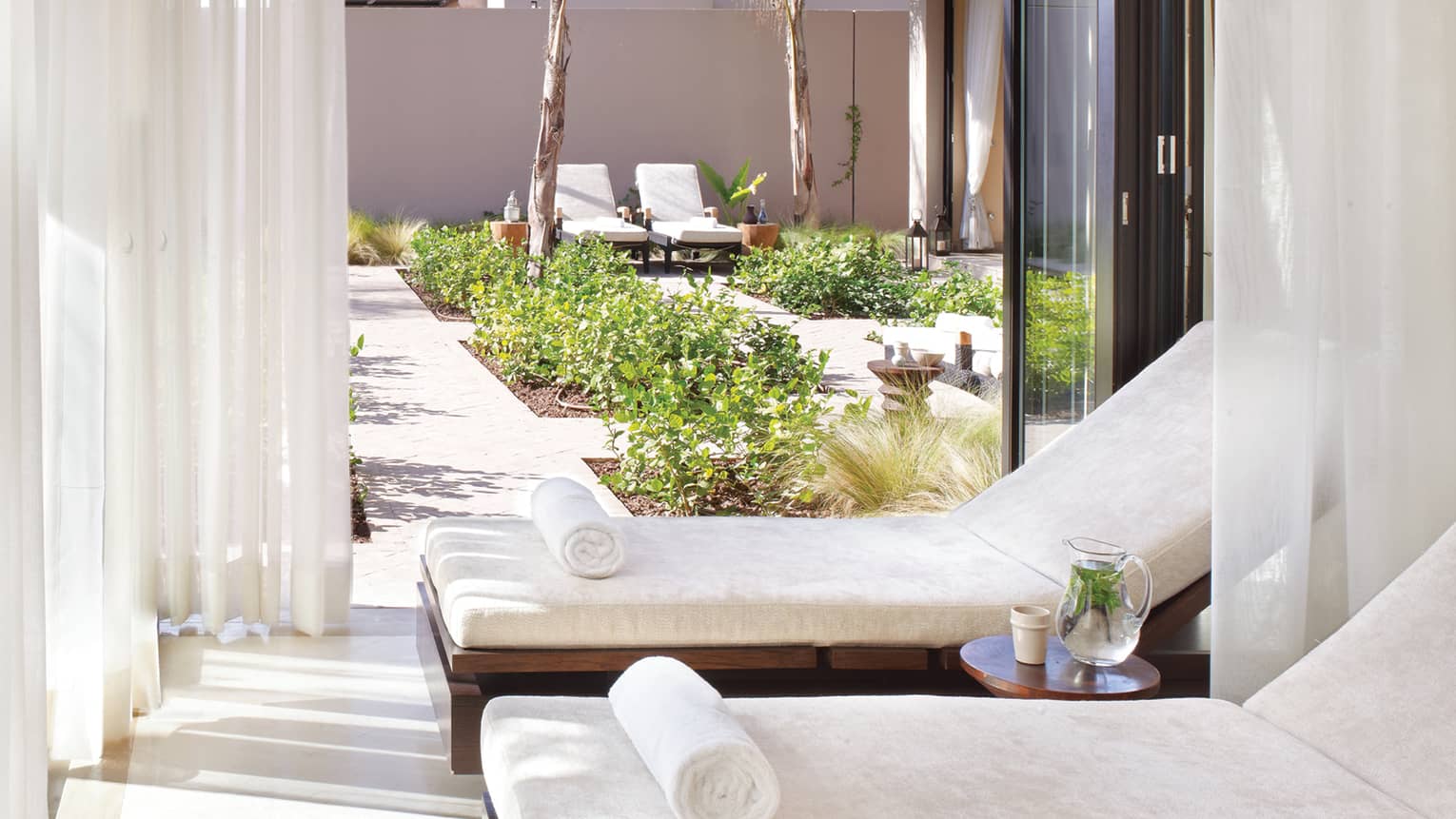 Two white lounge chairs in cabana on spa patio