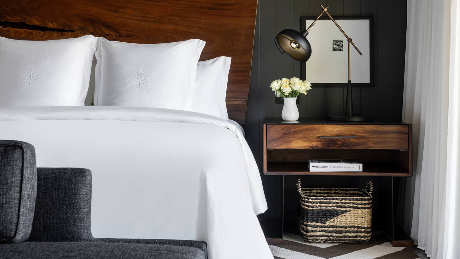White king bed with natural wood headboard, modern wooden night stand and lamp