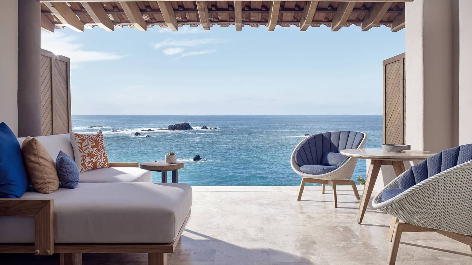 Sitting area with two chairs and one sofa, opening to the sea