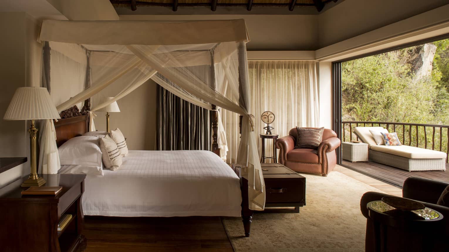 Two-bedroom villa side of poster bed with white canopy, open patio wall