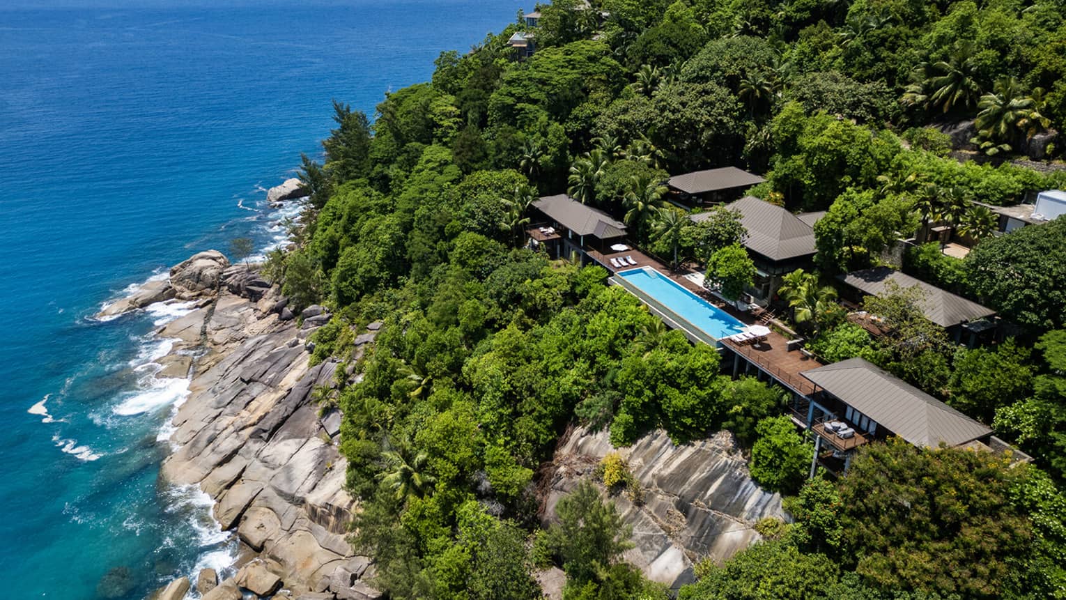 Large private villa on a lush cliff overlooking the sea in tropical location