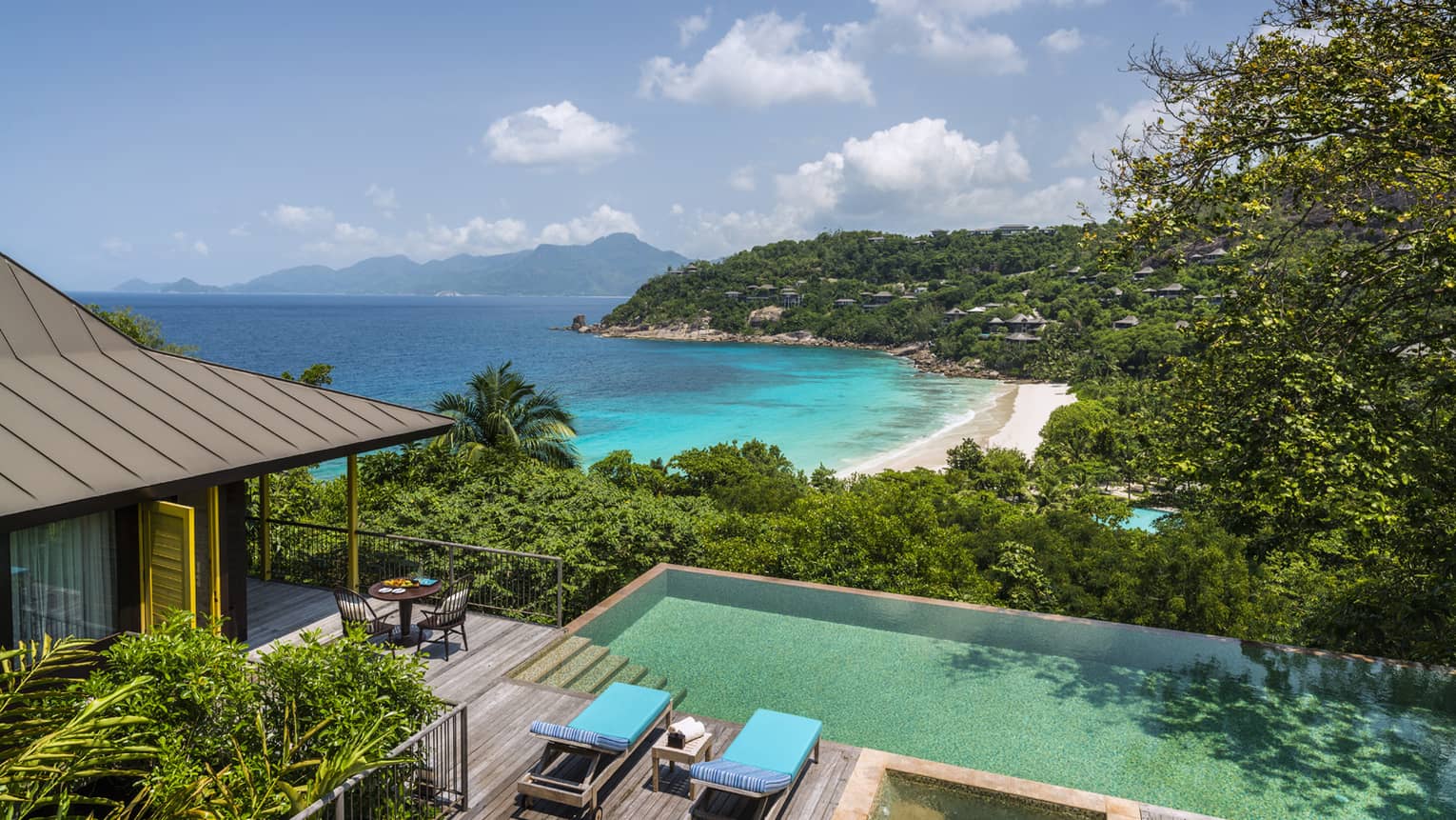 Aerial view of Two-Bedroom Ocean-View Suite pool, chairs and deck, mountain and ocean views