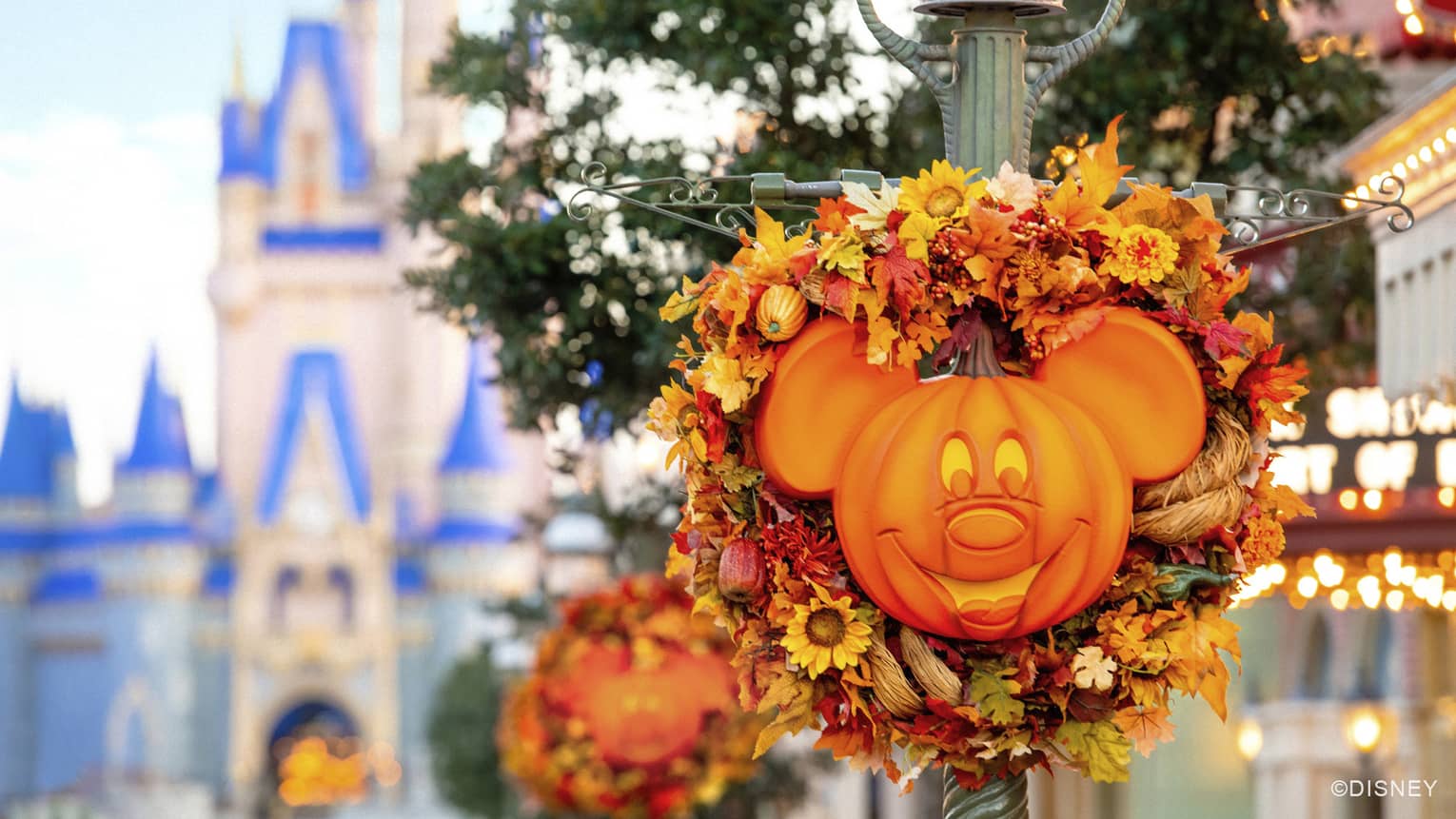A large cartoon mouse shaped pumpkin light on a lightpole.