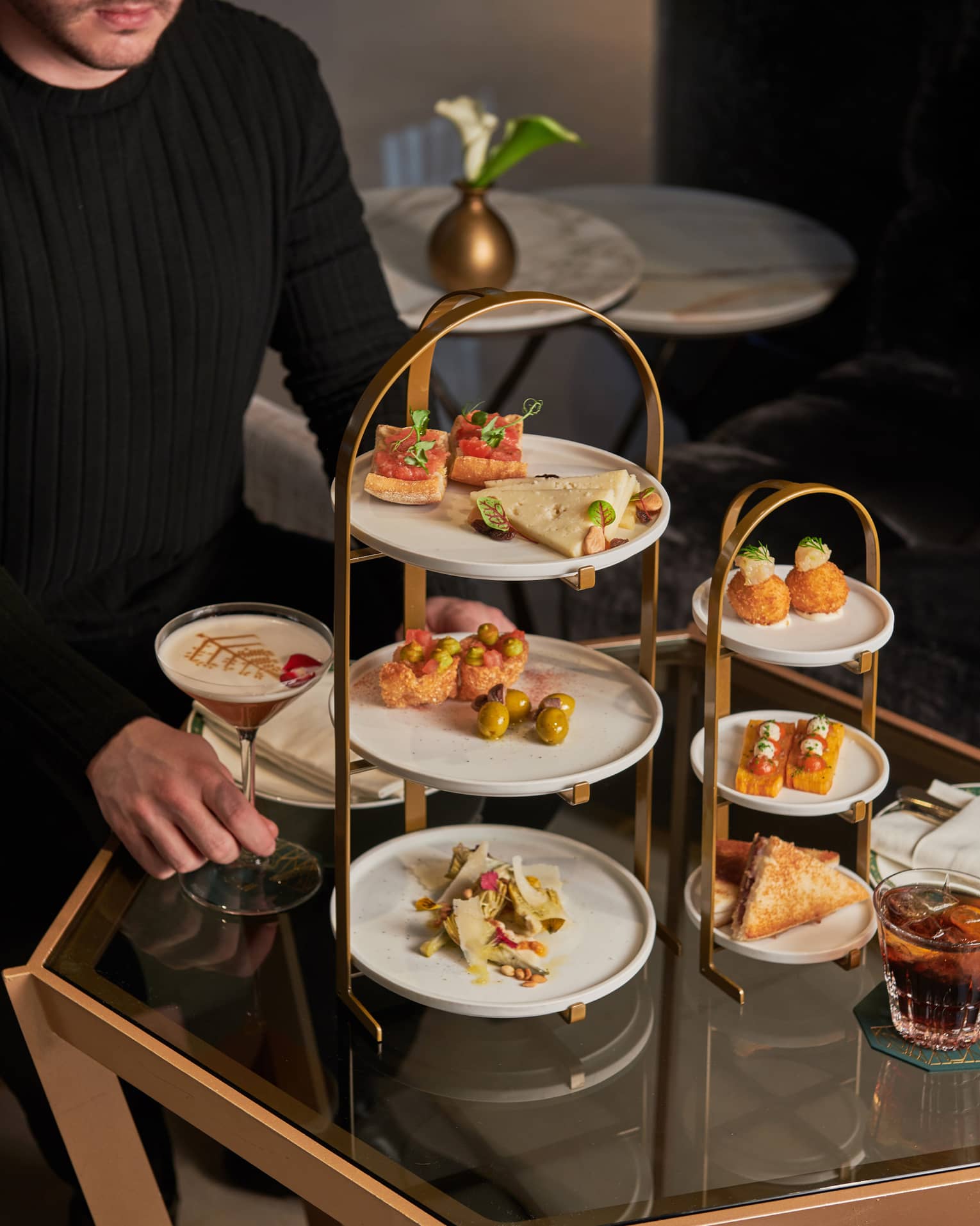 A server setting up tapas on a three-tiered afternoon tea stand