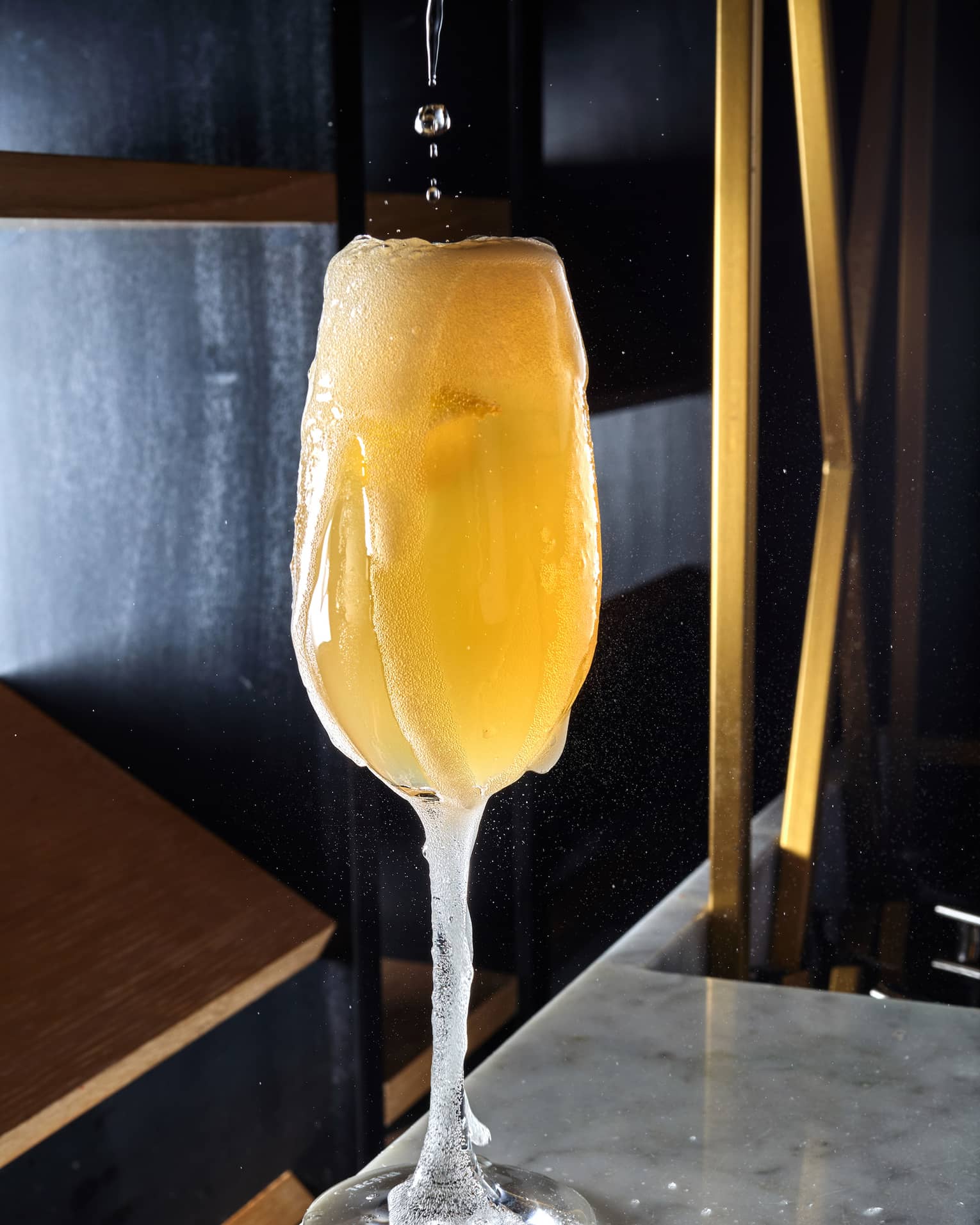 A champagne glass being filled with a drink