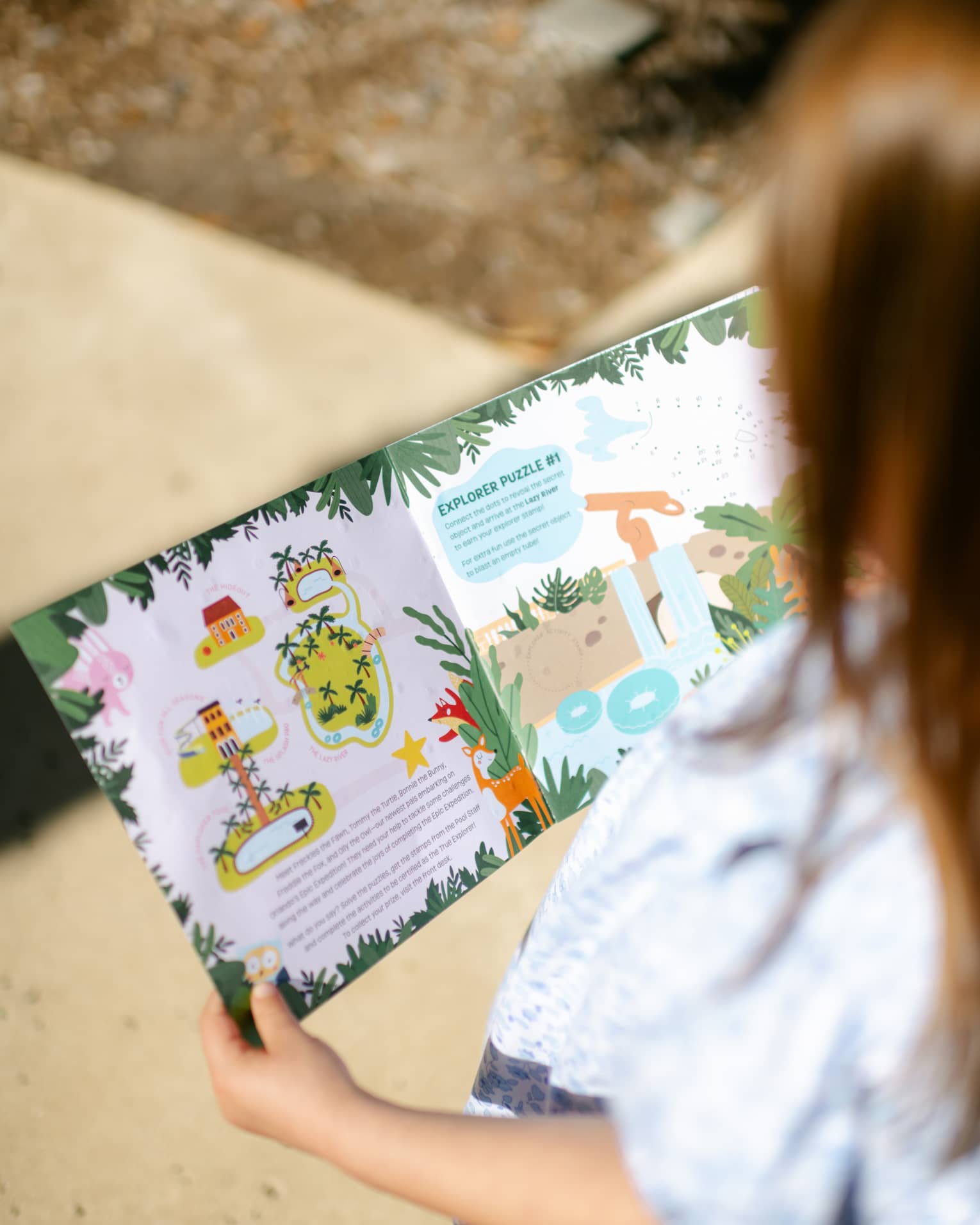 A young guest reading a picture book outside