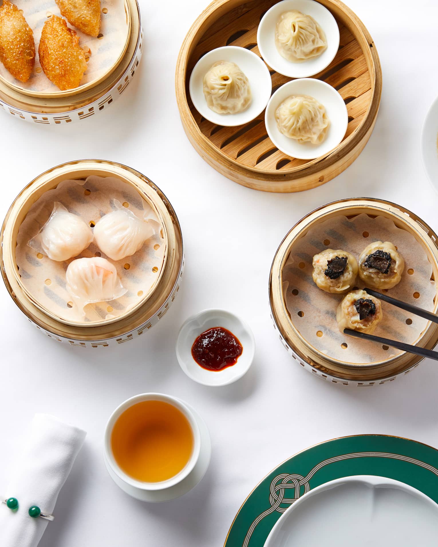 Aerial shot of Dim Sum selection, man reaching for dumplings steamer basket with chopsticks