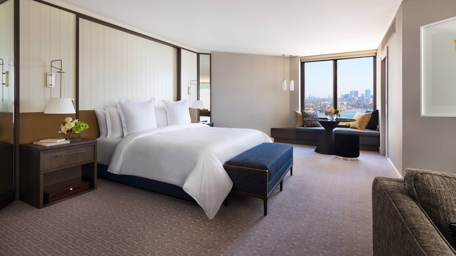 Spacious hotel room with king bed and partial views of Sydney Harbour