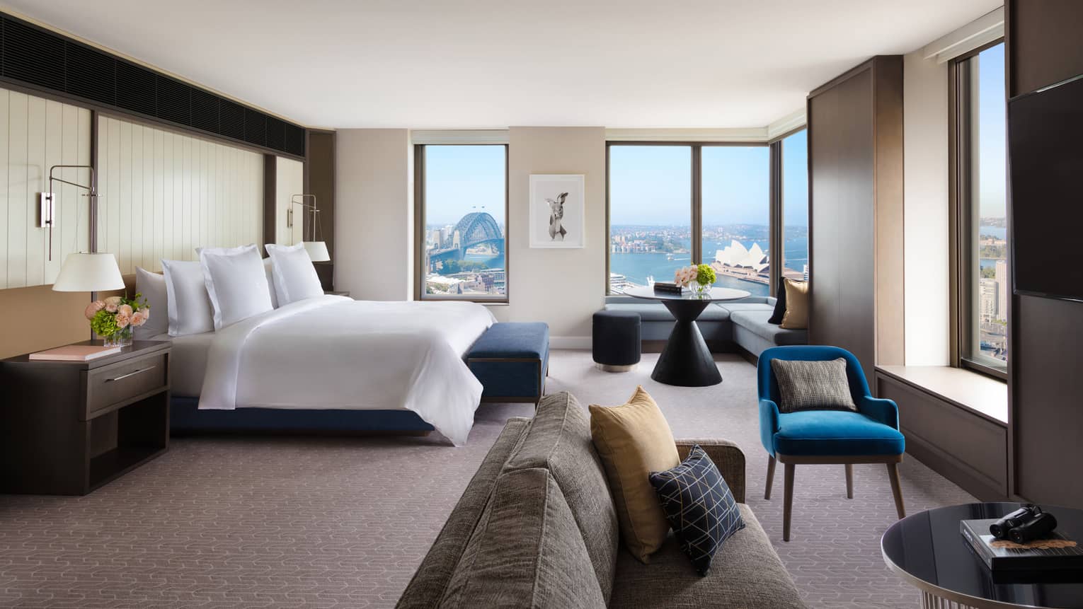 A cozy bedroom with subtle bursts of colourful decor, overlooking the iconic Sydney Harbour