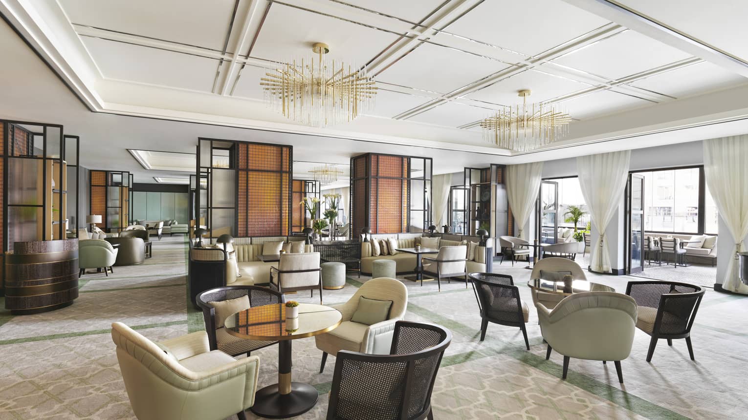 Interior of hotel lounge dining area featuring small round tables and upholstered chairs