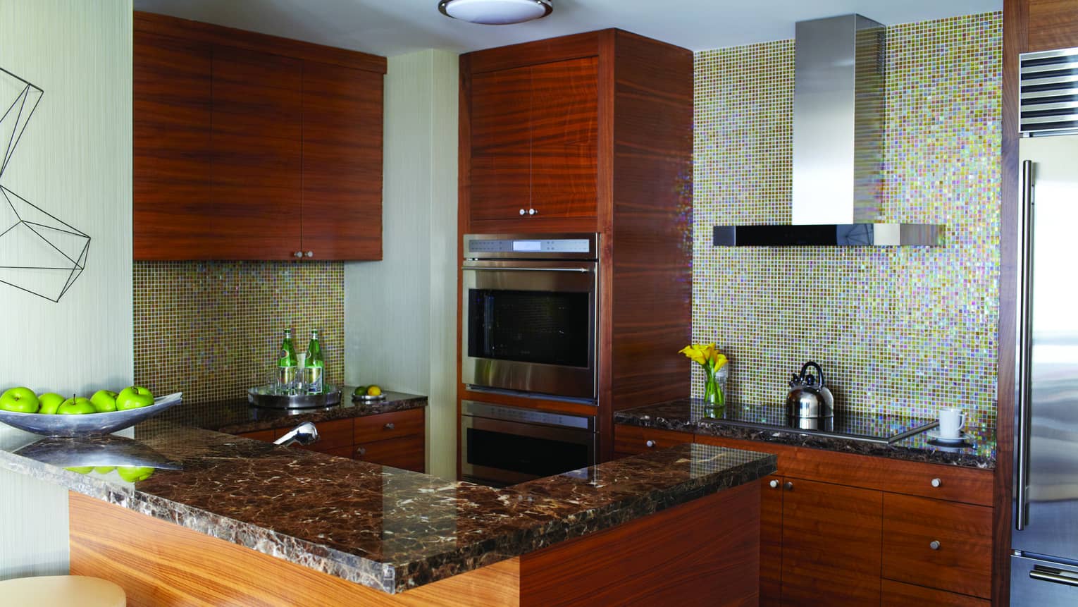 A kitchen with wood cabinets and an island with two chairs