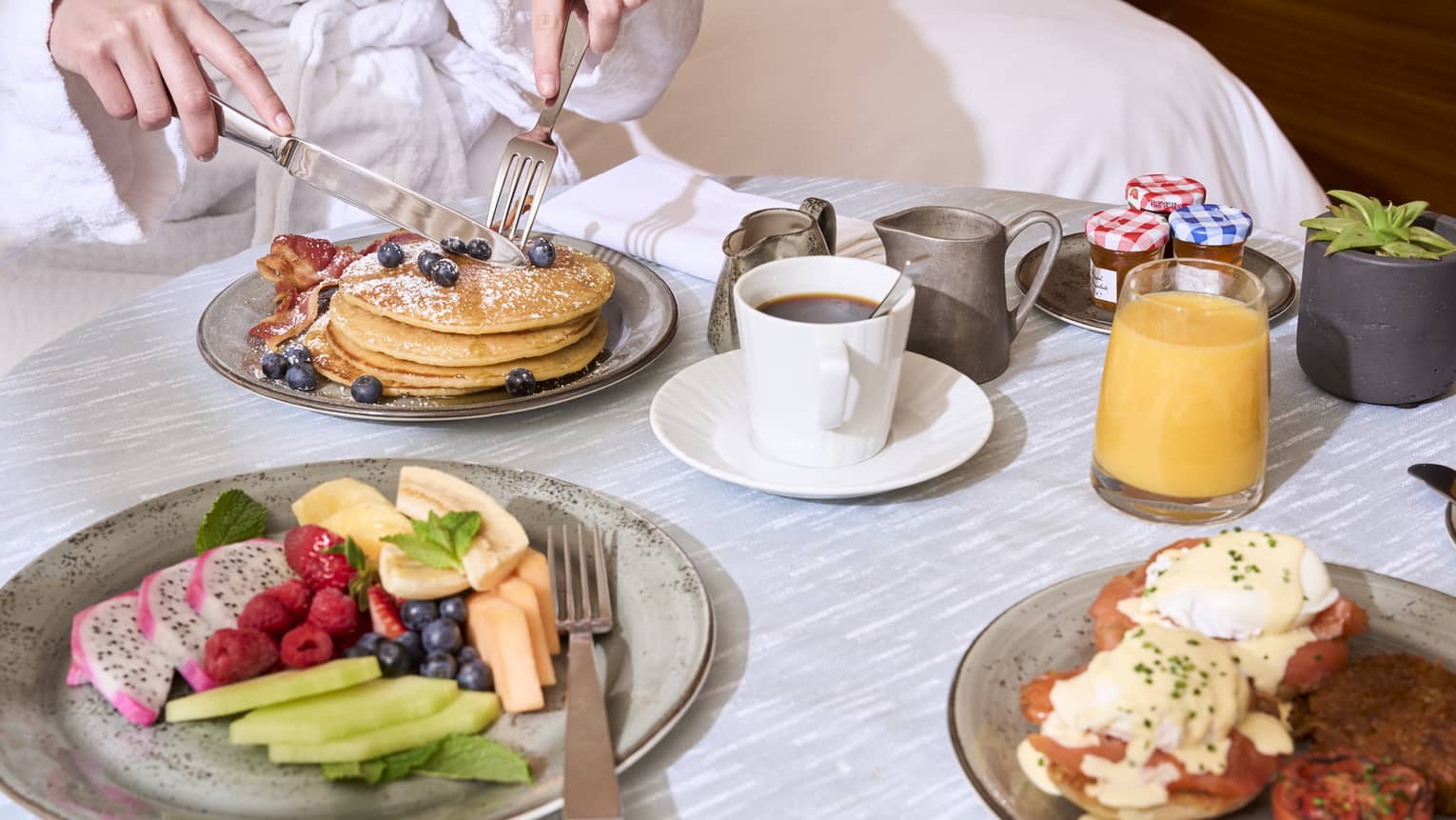 An assortment of breakfast food on a light grey table.
