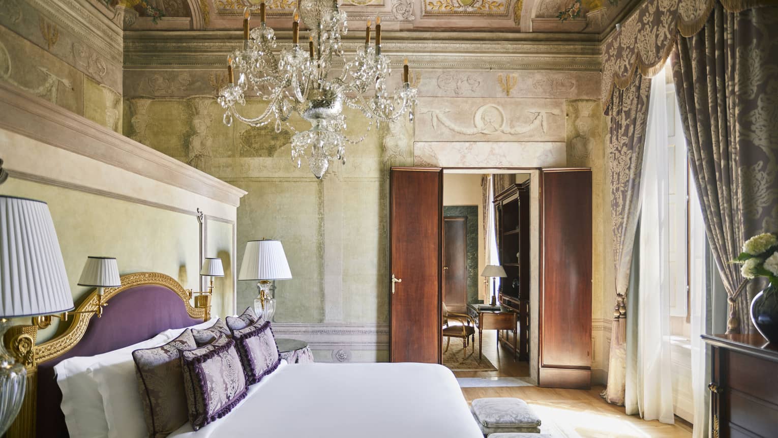 Frescoed Executive Suite bedroom with king bed and crystal candelier at Four Seasons Hotel Florence