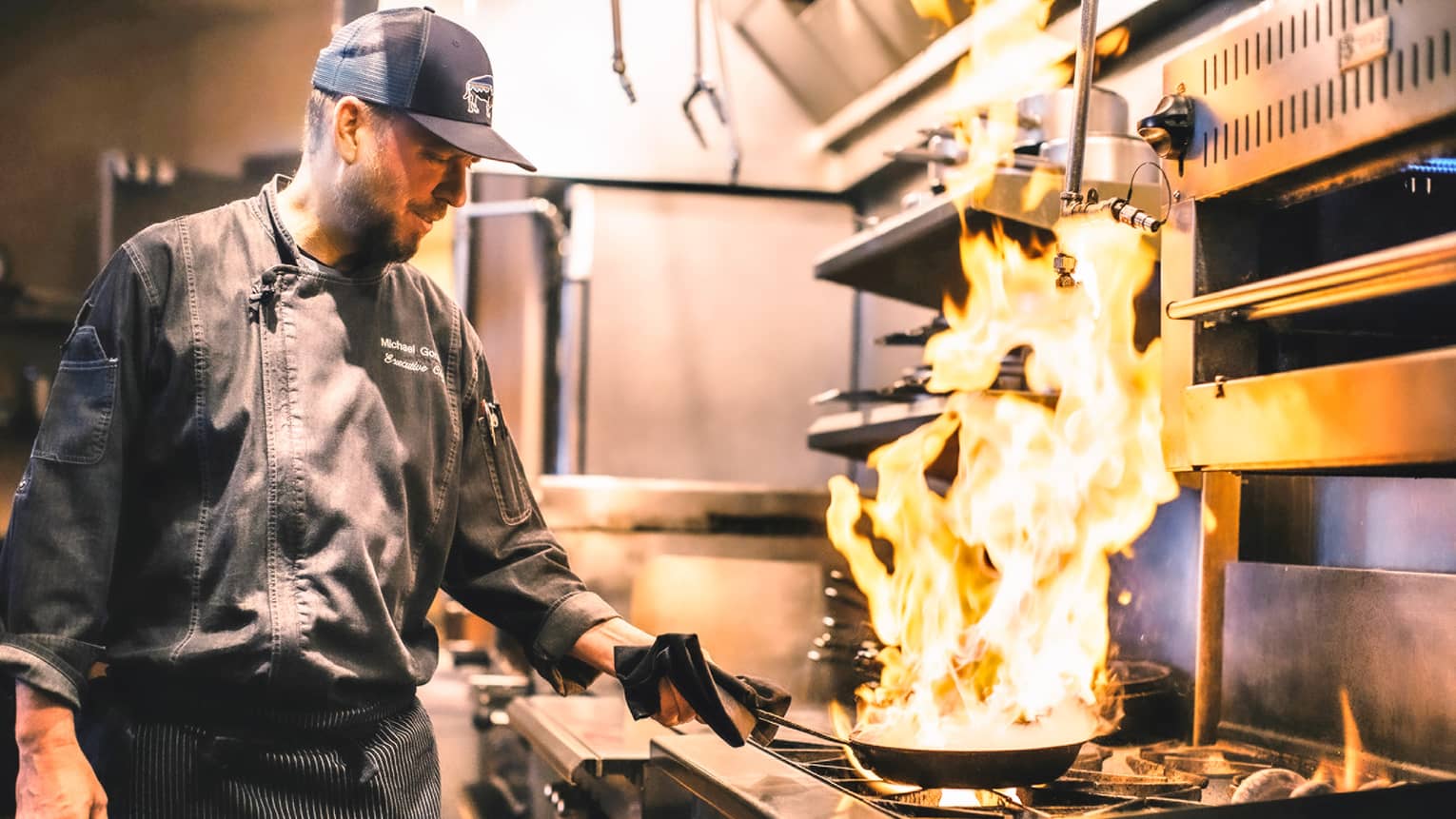 Chef Michael flambés food in a skillet