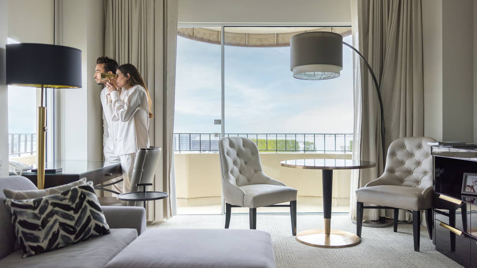 Two guests looking out of the window of their guest room