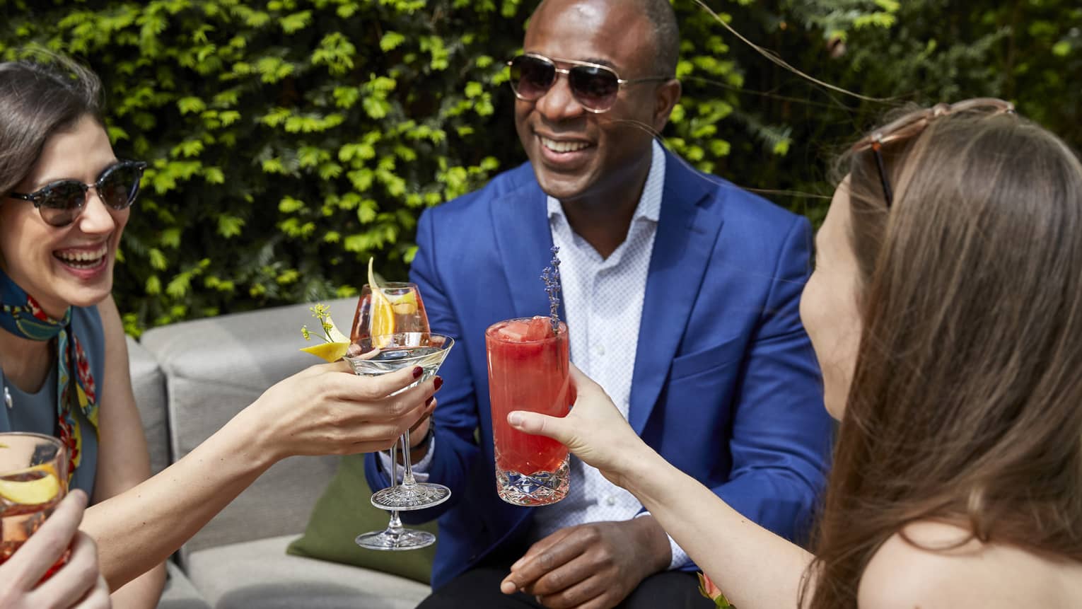Guests cheers hand crafted cocktails outside on a terrace