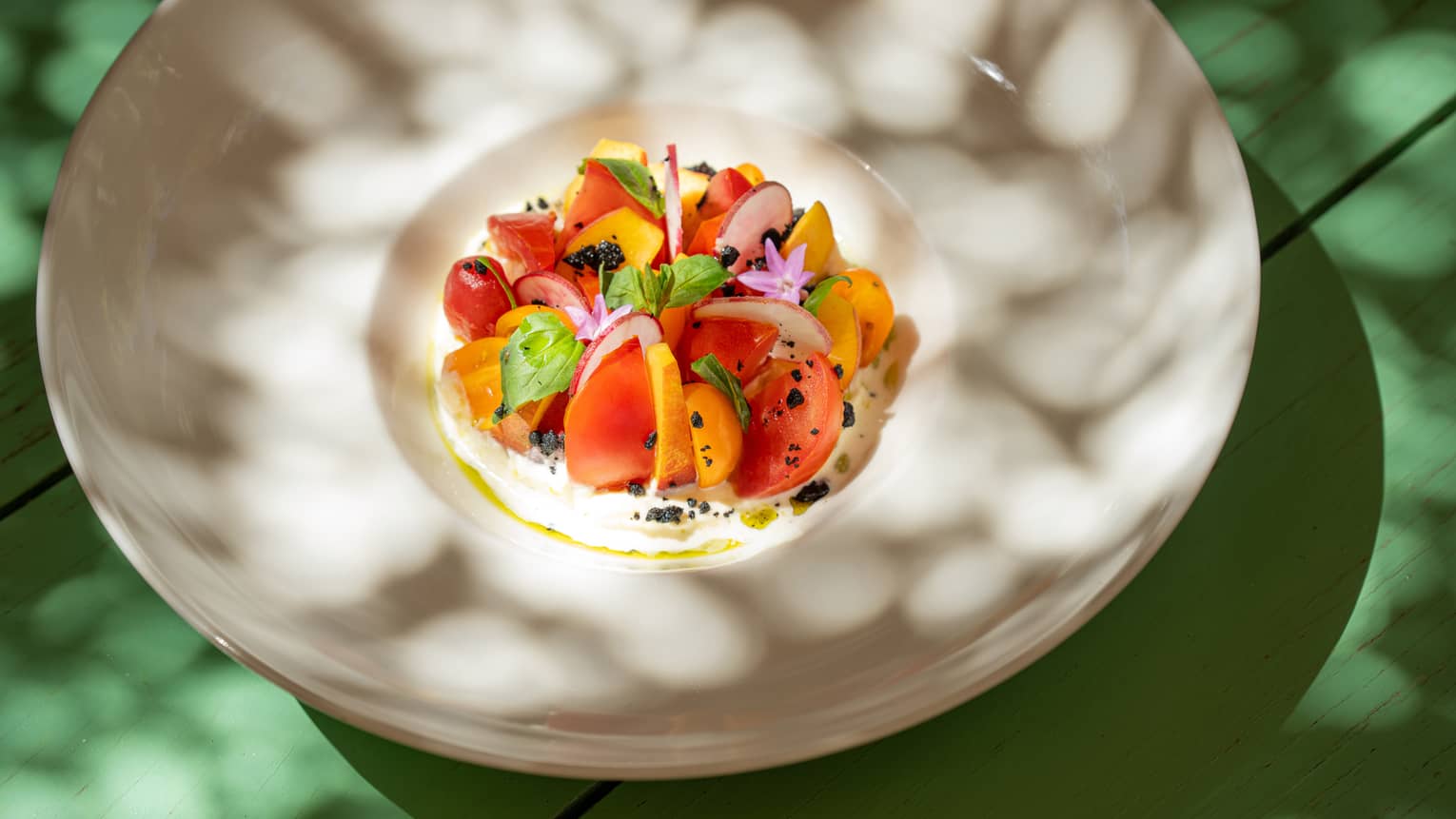 Stracciatella with Heirloom Tomato Wedges, Sliced Peaches and Basil Leaves in ecru bowl