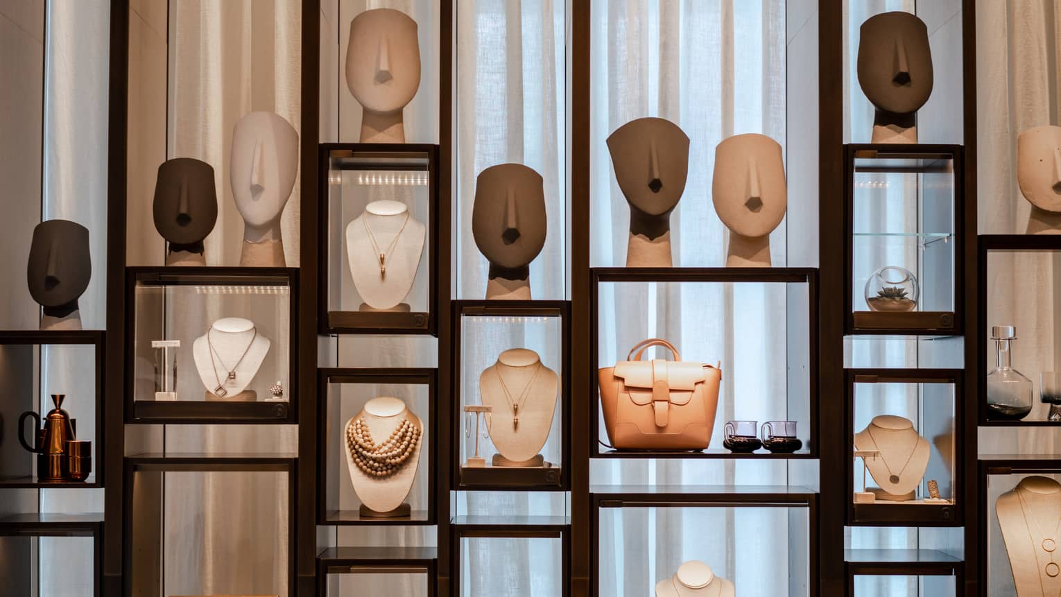 Wooden and glass display case with merchandise like jewelry and handbags
