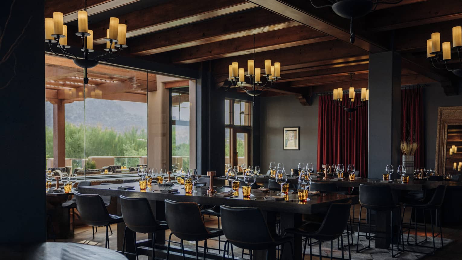 Dining room with multiple chandeliers and tables with candles.