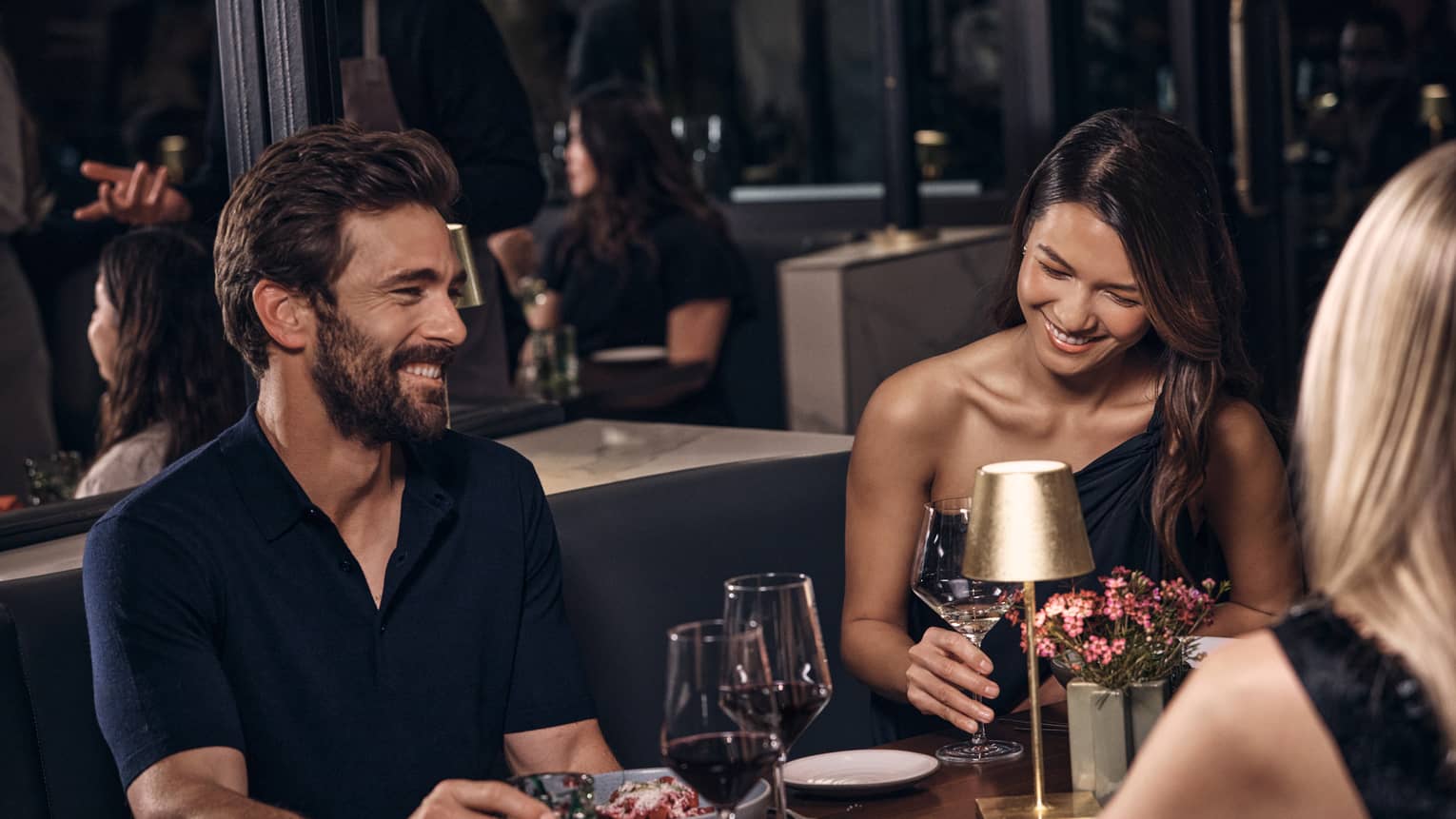 Three guests sitting at a dining table while talking and laughing.