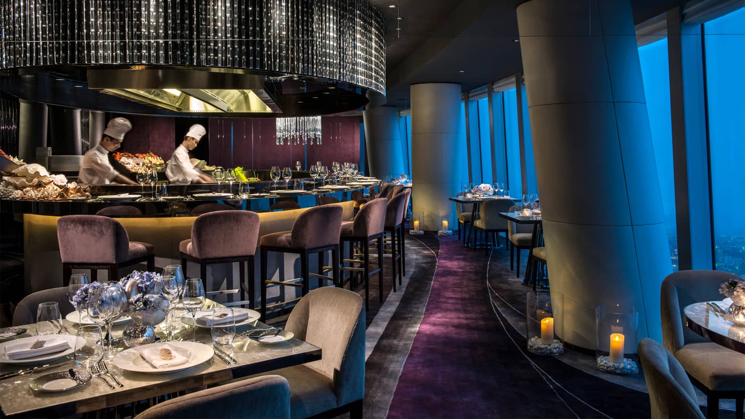 Two chefs in uniform behind round black seafood bar at Catch, Guangzhou's highest hotel restaurant